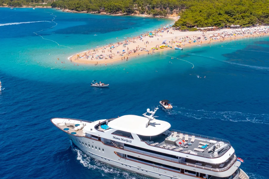 Golden Horn beach (Zlatni Rat) in Bol, island Brač, Croatia, with luxury yacht Mama Marija II and turquoise waters, a renowned destination for travelers worldwide.