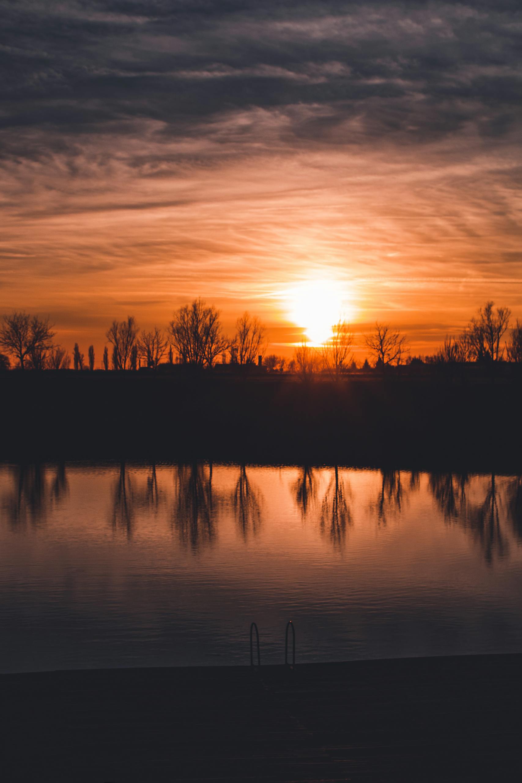 Beautiful sunset over a tranquil lake in Osijek, Croatia, with calm reflection and scenic skyline.